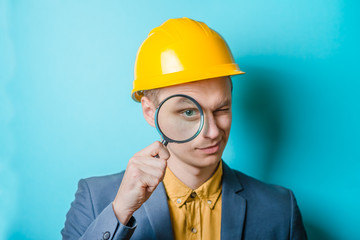 Young man engineer with magnifier