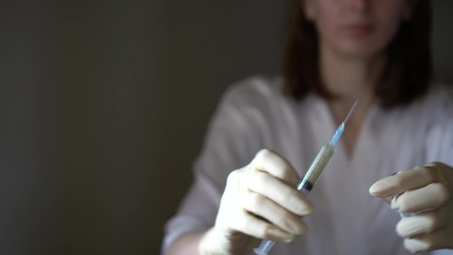 Self-injection of antibiotics. Female preparing needle for injecting her buttocks. Woman injecting buttocks.
