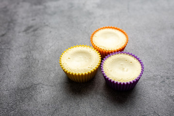 Mini cheesecakes with whipped cream topping, healthy summer treat on grey stone table