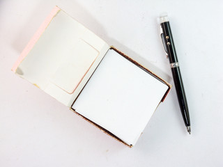 Note pad and black pen on a white background.