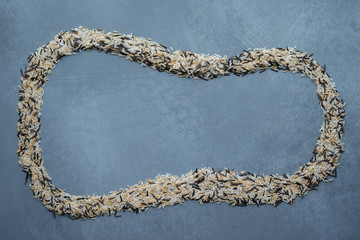 Cloud shape copy space made of three type of rice: white, brown and black on grey background. Top view.