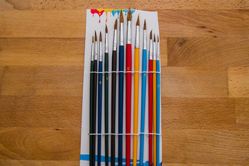 Obraz premium colored brushes on a wooden table