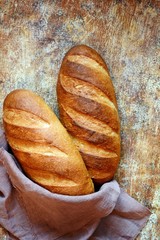Fresh loaf on a brown background.  Traditional wheat freshly rustic baked bread, loaf of bread.
