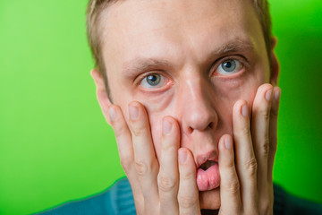 Fototapeta premium a young man dragging face down with hands