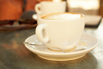Trendy woman drinking coffee outdoors. Focus on cup.
