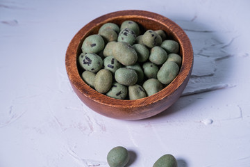 Spicy Wasabi snack with nori isolated in a wooden bowl on white background.