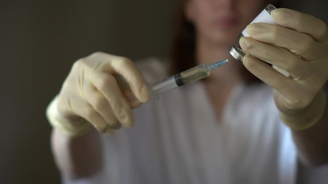 Self-injection of antibiotics. Female preparing needle for injecting her buttocks. Woman injecting buttocks.