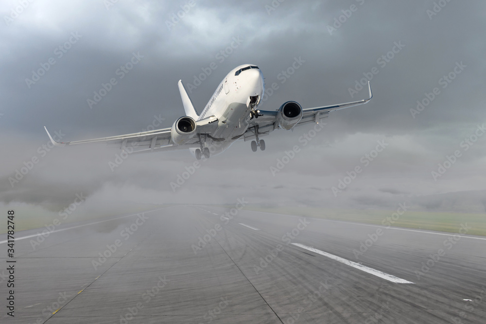 Wall mural passenger airplane leaving for the second go around, after an unsuccessful attempt to landing in bad