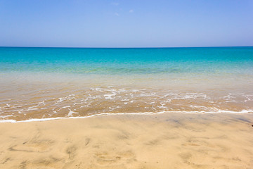 Fototapeta na wymiar Calm sea on empty beach with turquoise water. Nobody on colorful seashore of tropical island. Idyllic summer holidays, paradise destintation concepts