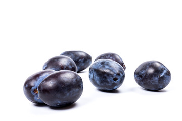 Fresh blue plums, isolated on white background, in close-up.