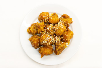 Chinese Sesame Chicken on white background.This Chinese Sesame Chicken is made with boneless skinless chicken thigh, cut into bite-size pieces and fried until golden and crispy.