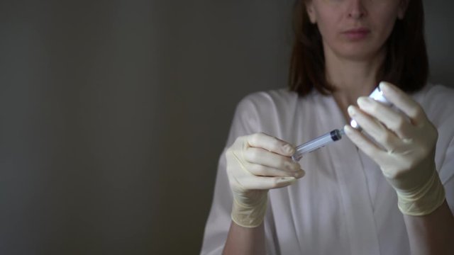 Self-injection of antibiotics. Female preparing needle for injecting her buttocks. Woman injecting buttocks.