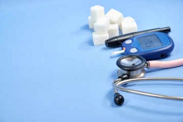 The glucometer with the test strip on a blue background. space for text, selective focus