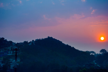 Setting the Sun at dusk from Guatemala City, silhouetted by mountains and trees, peaceful dusk in the middle of the Covid 19 pandemic Central America.