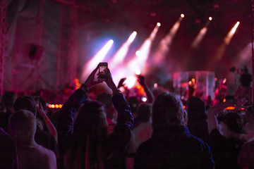 fans at a music concert dance and shoot video on the phone