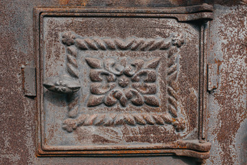 rusty stove door with handle and ornament