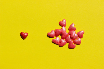 Blurry image of a pink and red small hearts on yellow background. Abstract love, Valentine`s Day concept.