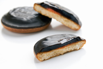 Close-up of a round delicious chocolate shortbread on a white background with a broken piece