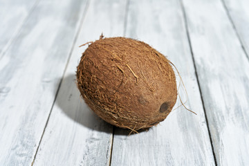 Dojrzały orzech kokosowy na drewnianym stole rustykalnym © piotrszczepanek