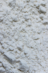 Blurry image of white flour, vertical view.  Abstract food backdrop. White powder texture background.