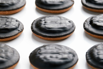 Close-up of a delicious round chocolate shortbread with filling on a white background. Side view