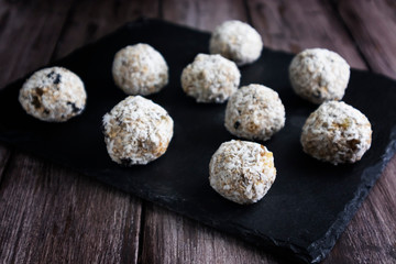 Raw cocoa and coconut energy balls on a wooden background, healthy sweets for breakfast, horizontal orientation