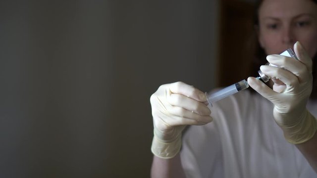 Self-injection of antibiotics. Female preparing needle for injecting her buttocks. Woman injecting buttocks.