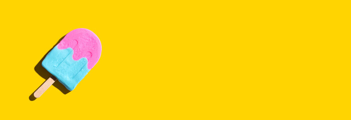 Pink and blue popsicle with shadow - overhead view