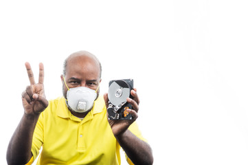 African American Man with peace sign and hard drive wearing medical mask for COVID 19 protection.  Concept of Lockdown, Flatten the Curve, Social Distancing, State of Emergency,  