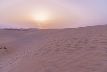 colorful sunset over desert sand dunes