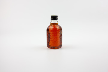 A small bottle of brown liquid that looks like rum. Indian rum.