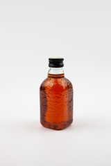 A small bottle of brown liquid that looks like rum. Indian rum.