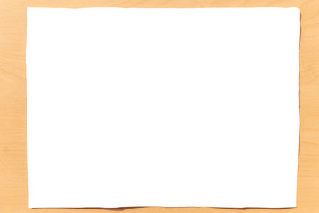 Blank white paper on bright wooden office desk. Empty sheet of paper on wood table.