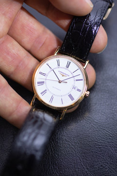 Saint-Imier, Switzerland 31.03.2020 - Closeup image of Longines watch in the male palm Longines man watch stainless steel case white clock face dial leather strap swiss quartz watch swiss made