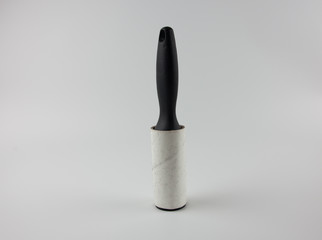 Sticky roller for collecting dust, wool, hair. Cleaning clothes at home.