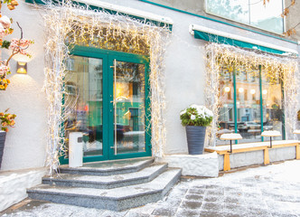 Cafe facade with lights and snowy asphalt