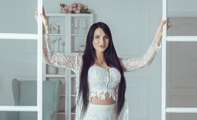 Brunette woman with long hair opening doors in living room