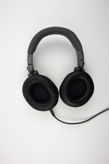 Black wired professional headphones for working with music on a white background.