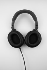 Black wired professional headphones for working with music on a white background.