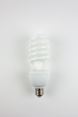 White energy-saving bulb on a white background. The lighting of the premises.