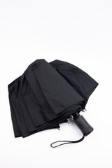 Black beautiful umbrella with a black handle on a white background. Protection from rain and other precipitation.