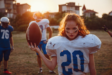 American football woman player in action on the stadium.