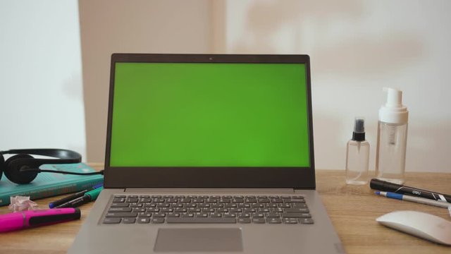 On table laptop with green screen on working space in home office notebook business internet interior technology mockup design laptop blank workspace display