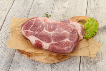Raw pork steak over wooden board