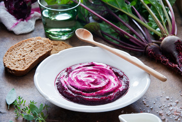 Creamy Beetroot soup on brown wooden background
