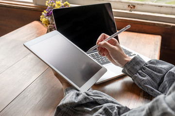 Business woman working at home with her laptop and tablat