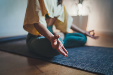 Home Yoga Flow, Closeup of young woman making mindfulness meditation at home sitting in lotus pose...