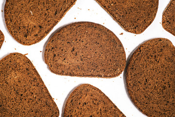 Whole wheat bread on the table. Top view of slices of fresh black bread on a white background.
