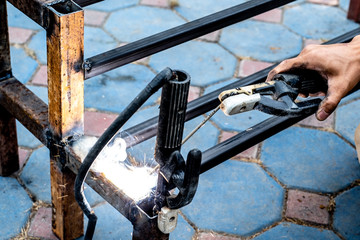 The mechanic is using a welding machine to weld steel