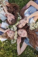 Fototapeta premium Four Teen girls enjoys spring in daisy field.